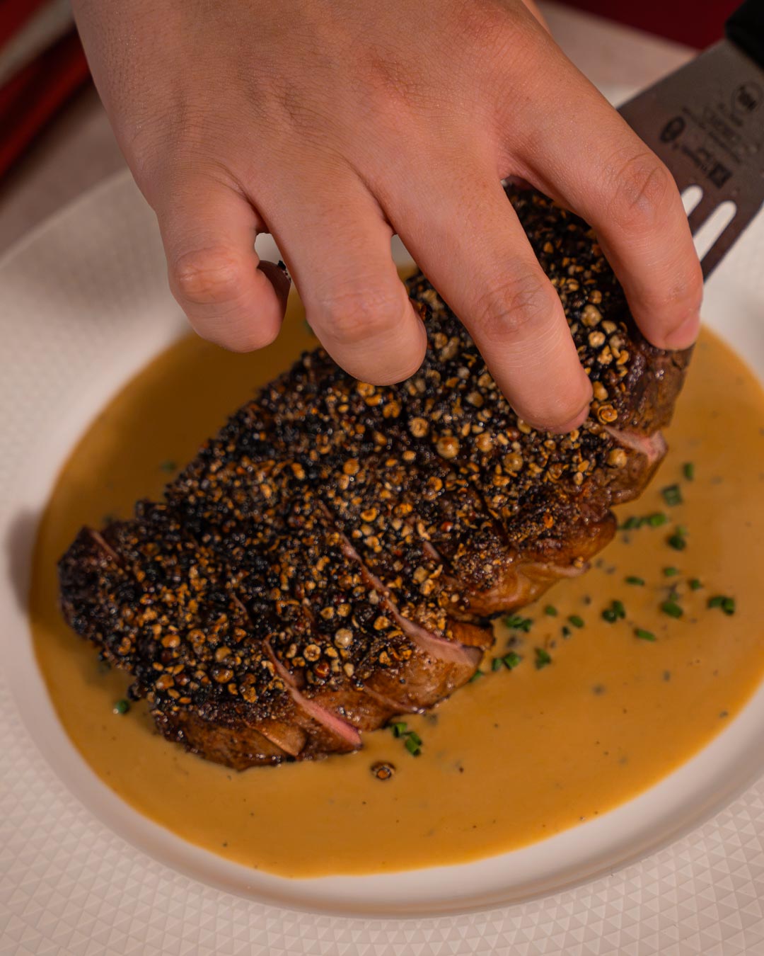 Steak au poivre being carved at Emir Brasserie